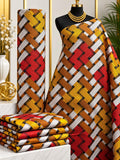 Amber Interlace African print cotton fabric in yellow, rust, white and black, featuring bold diagonal interwoven ribbon-like bands; shown draped and folded.