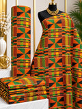 Harvest Pinwheel African print cotton fabric in orange, green, yellow and black, featuring angular triangles and rectangles forming a compact geometric repeat; shown draped and folded.