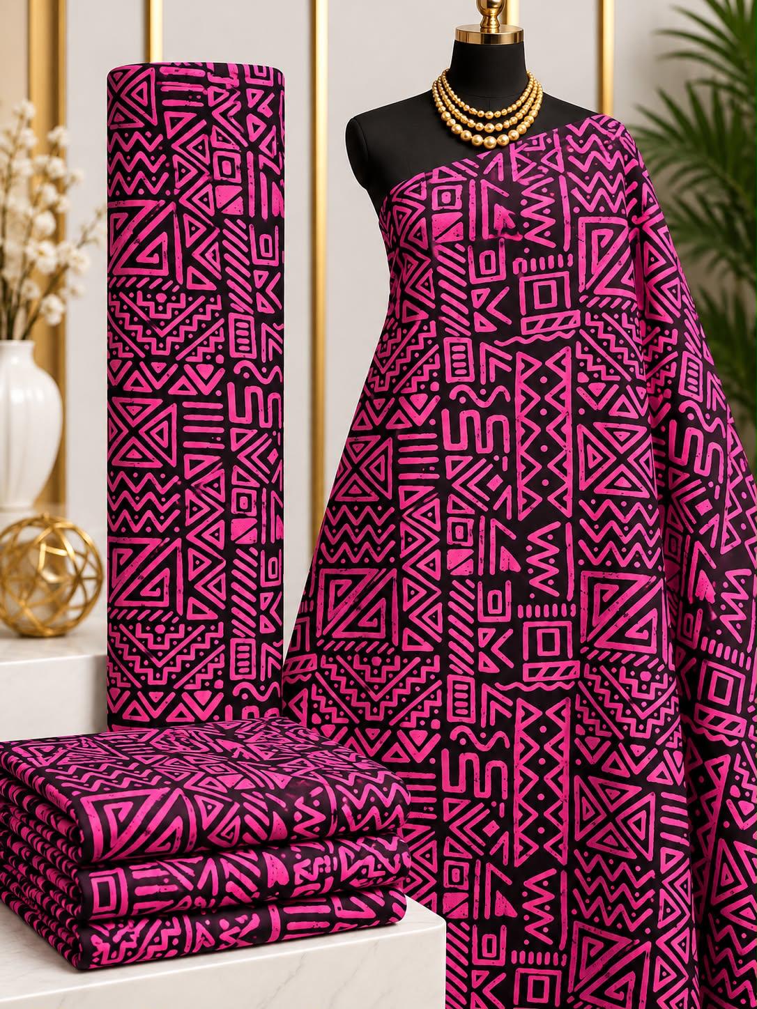 Magenta Markwork African print cotton fabric in pink and black, featuring rectangular panels of angular lines, triangles and zigzags; shown draped and folded.