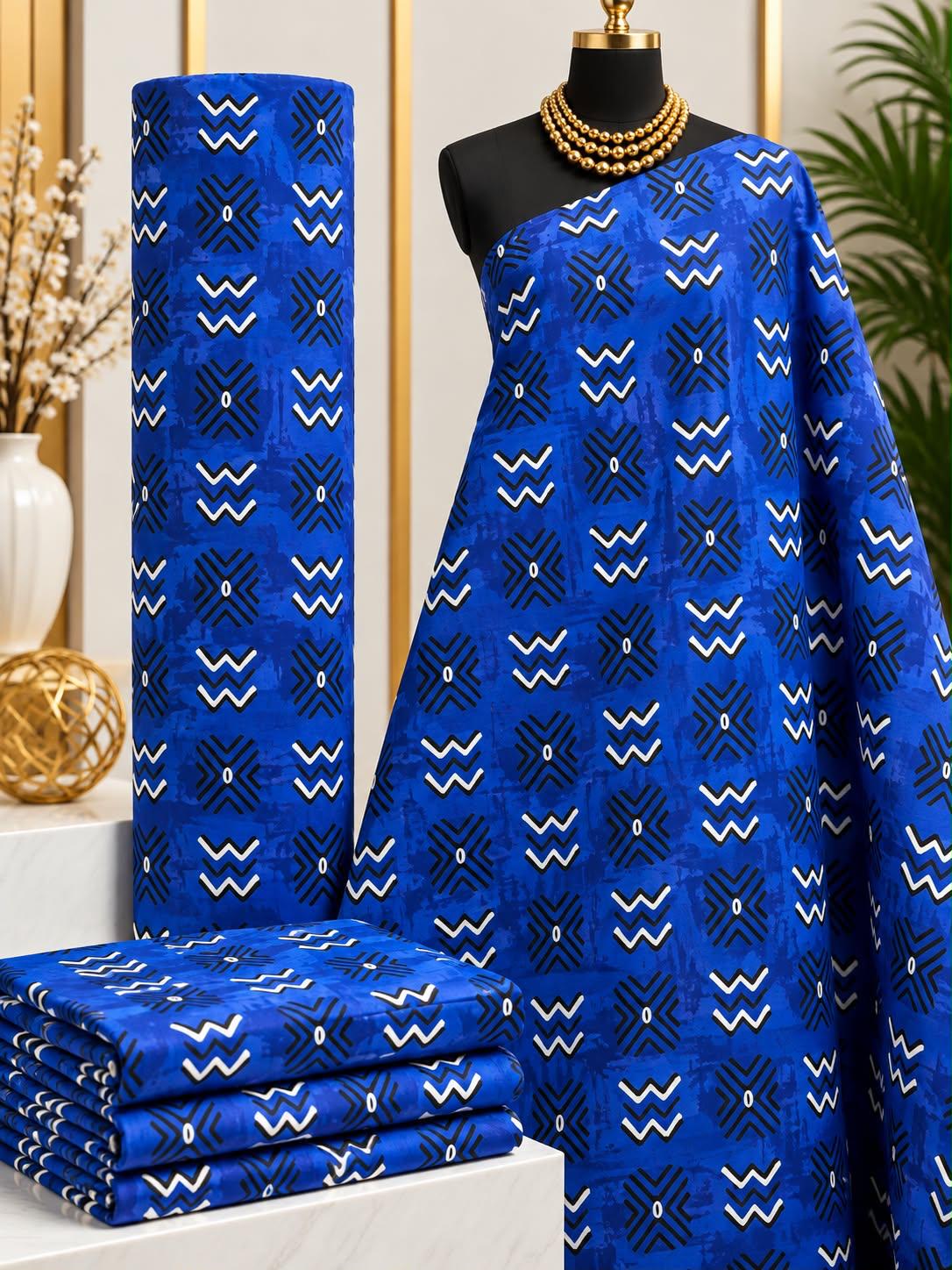 Cobalt Crowns African print cotton fabric in blue, yellow, white and black, featuring small repeated crown-like angular marks and fine vertical accents; shown draped and folded.
