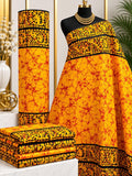 Marigold Border African print cotton fabric in orange, yellow and black, featuring fine branching marks with dark ornamental border bands; shown draped and folded.